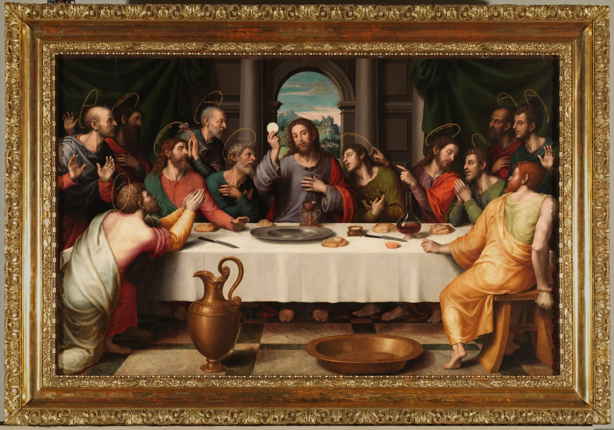 Christ sits at the center of the table, haloed in light, lifting the host in blessing above a chalice, while the twelve apostles lean in around him in wonder and adoration at the first Eucharist.